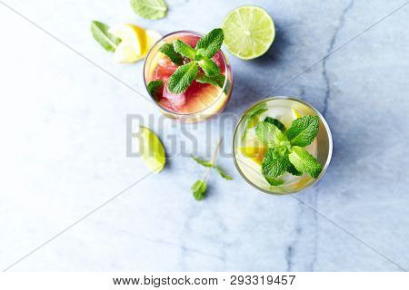 Home made Apple-Lemon and Raspberry-Lemon Lemonade with mint leaves and ice. Summer fruit drinks. Copy space