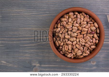 A Plate Of Beans On Wooden Table Background