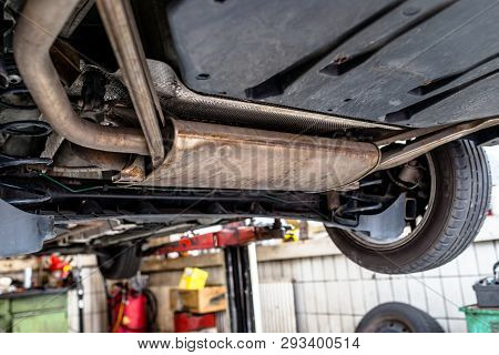 The Exhaust System In The Car Seen From Below, The Car Is On The Lift In The Car Workshop.