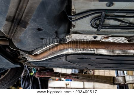 The Exhaust System In The Car Seen From Below, The Car Is On The Lift In The Car Workshop.