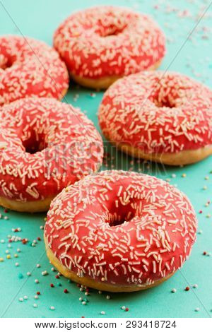 Donuts Decorated With Icing On Blue Background.