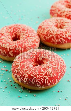 Donuts Decorated With Icing On Blue Background.
