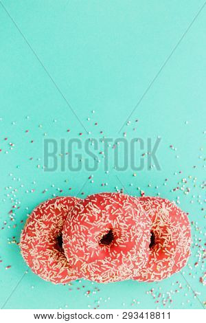 Donuts Decorated With Icing On Blue Background.