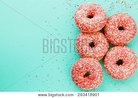 Donuts Decorated With Icing On Blue Background.