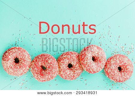 Donuts Decorated With Icing On Blue Background.