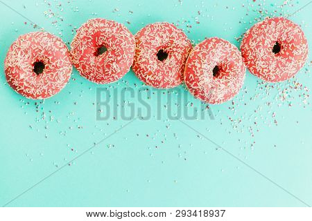 Donuts Decorated With Icing On Blue Background.