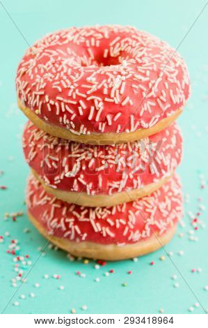 Donuts Decorated With Icing On Blue Background.