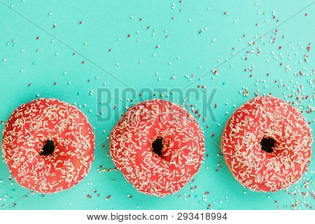 Donuts Decorated With Icing On Blue Background.