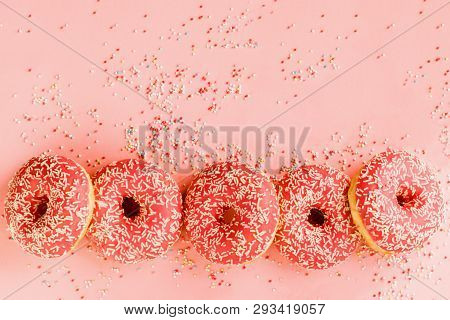Five Coral Donuts Lying In A Line.