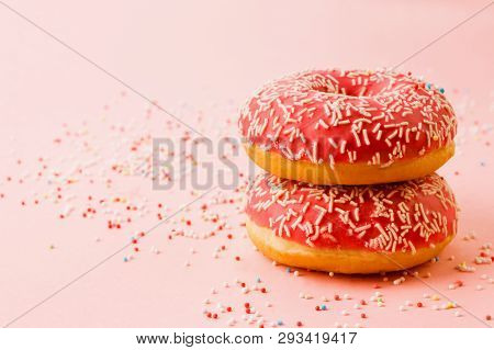 Two Coral Donuts Standing In A Line. Donuts Decorated With Icing