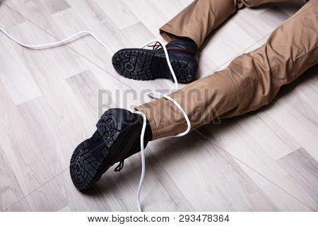 Low Section Of Male Electrician Wrapped In Wire Fallen On Floor