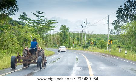 Farmer Driving Tractor On Highway In Thailand Behind Car