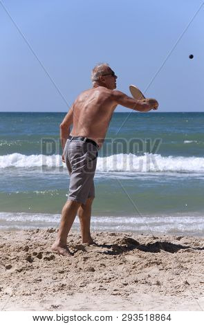 Handsome Grown Man Playing Tennis On The Beach