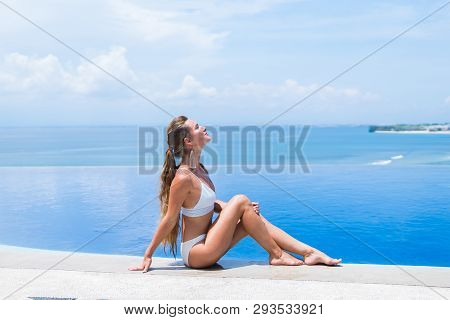 Sexy Girl. Beautiful Woman. Model Lady Bikini Underwear Sit Edge Of Water Swim Pool On The Roof Of L
