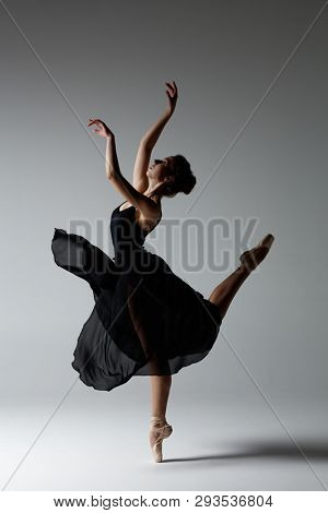 Young beautiful ballerina is posing in studio