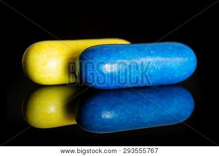 Group Of Two Whole Yellow And Blue Sweet Licorice Comfit Isolated On Black Glass