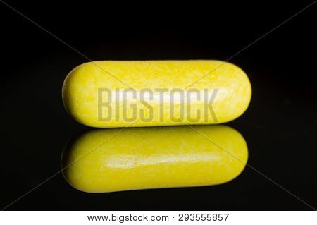 One Whole Yellow Sweet Licorice Comfit Isolated On Black Glass