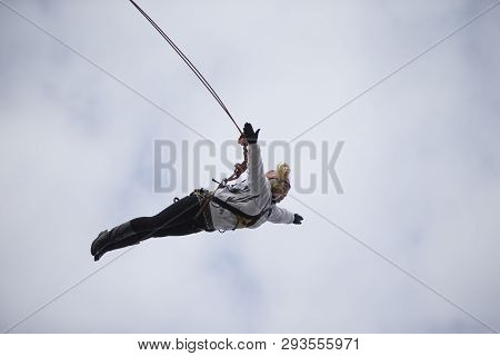Belarus, Gomel, March 08, 2019. Jumping From The Bridge To The Rope.ropejumping.an Elderly Woman Jum