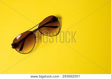 Sunglasses Lie On A Yellow Background, Close-up