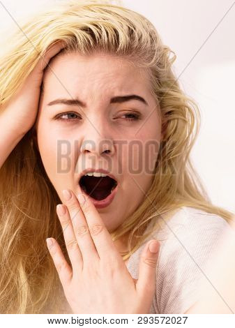 Young Blonde Female Feeling Dull And Tired After Waking Up. Woman Yawning Being Sleepy In Bathroom.