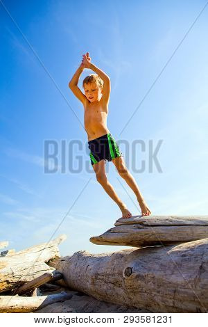 Happy Kid Jumping From The Log On The Sky Background