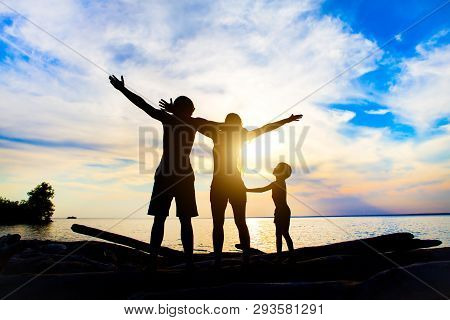 Happy Family Silhouette With Hands Up On The Sunset Background
