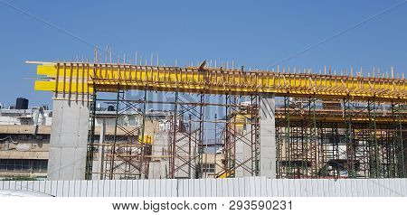 Construction Site Over A Fence With Concrete Columns Metal Beams And Wooden Scaffolding For Future B