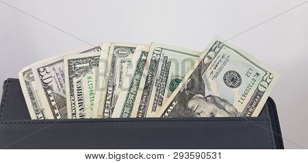 Close Up Of American Dollar Bills In A Pocket Of Black Leather Folder