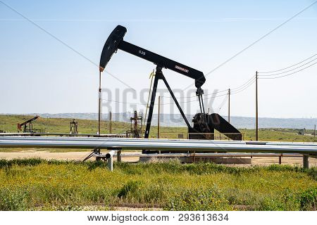 Taft, California - March 25, 2019: An Oil Derrick Works In The Field On A Sunny Day. California Is O