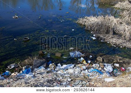 Garbage Thrown To The Bank Of The River, The Topic Of Environmental Pollution