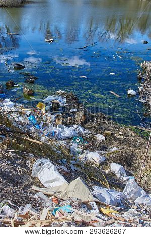 Garbage Thrown To The Bank Of The River, The Topic Of Environmental Pollution