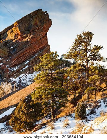 Snow Covered Hillside And Red Rock Formations In The Colorado Rocky Mountains.
