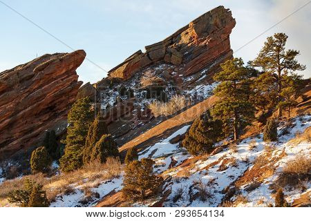 Snow Covered Hillside And Red Rock Formations In The Colorado Rocky Mountains.