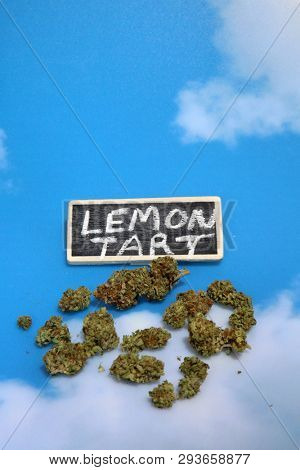 Marijuana. Cannabis. Recreational and Medical Marijuana Buds. Blue sky background with a small chalk board sign. Room for text. 