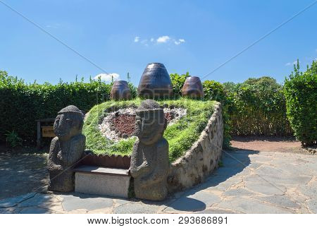 Jeju Island, South Korea, September 09, 2015: Statues Of Dol Hareubang At Folk Village With Blue Ski