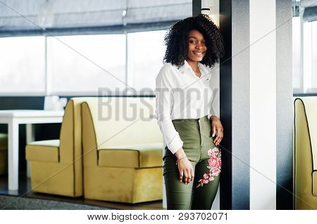 Сheerful Business African American Lady With Afro Hair, Wear White Blouse And Green Pants Posed In C