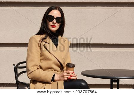Brunette Beautiful Females Its On Terrace, Drinks Aromatic Hot Coffee, Wears Elegant Coat And Leathe