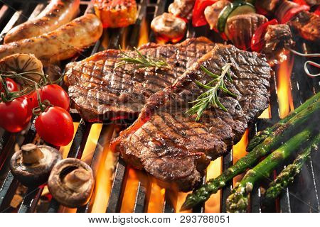 Assorted delicious grilled meat with vegetables sizzling over the coals on barbecue