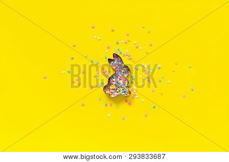 Easter Bunny Shape Form And Scattering Multicolored Confectionery Topping Dressing On Yellow Paper. 