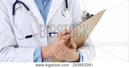 Female Doctor Using Medical Form On Clipboard Closeup.  Physicianat Work In Hospital Or Clinic. Heal