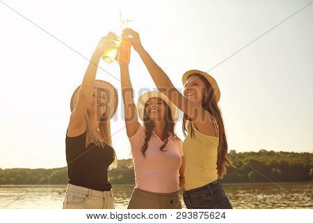 Girlfriends At A Party  With Drinks Up On The Beach.