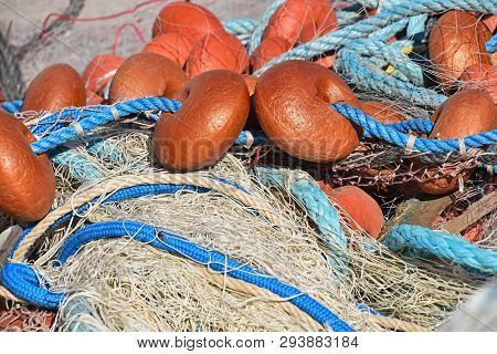 Close Up Background Of Heap Coils Of Sea Fishing Net With Colorful Vivid Floats And Cable Ropes At H