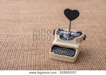 Retro Syled Tiny Typewriter Model On A Canvas Background