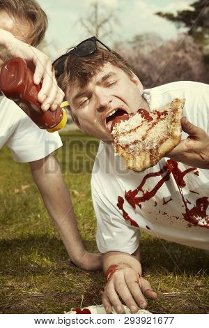 Men In Street Park Eating Langos With Garlic, Ketchup And Cheese