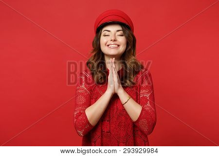 Portrait Of Smiling Young Woman In Lace Dress, Cap Keeping Eyes Closed, Holding Hands Folded Praying