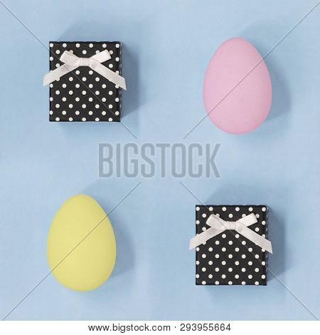 Gift Boxes With Pink And Yellow Easter Eggs, On A Pale Blue Background