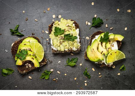 Sandwiches With Avocado And Cream Cheese With Grain Bread And Seeds. Black Slate Background, Top Vie