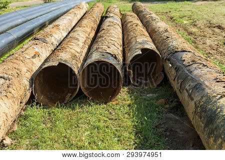 Fragments Of Old Large Water Pipes. After Many Years Of Operation, Corroded Metal Pipe Destroyed. Ru