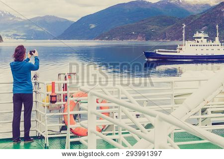 Tourism Vacation And Travel. Tourist Woman On Cruise Ship Enjoying Fjord View, Taking Photo With Cam