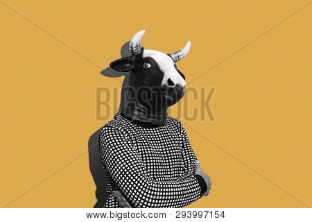 young caucasian man with a cow mask, in black and white, on a yellow background with some blank space on his both sides
